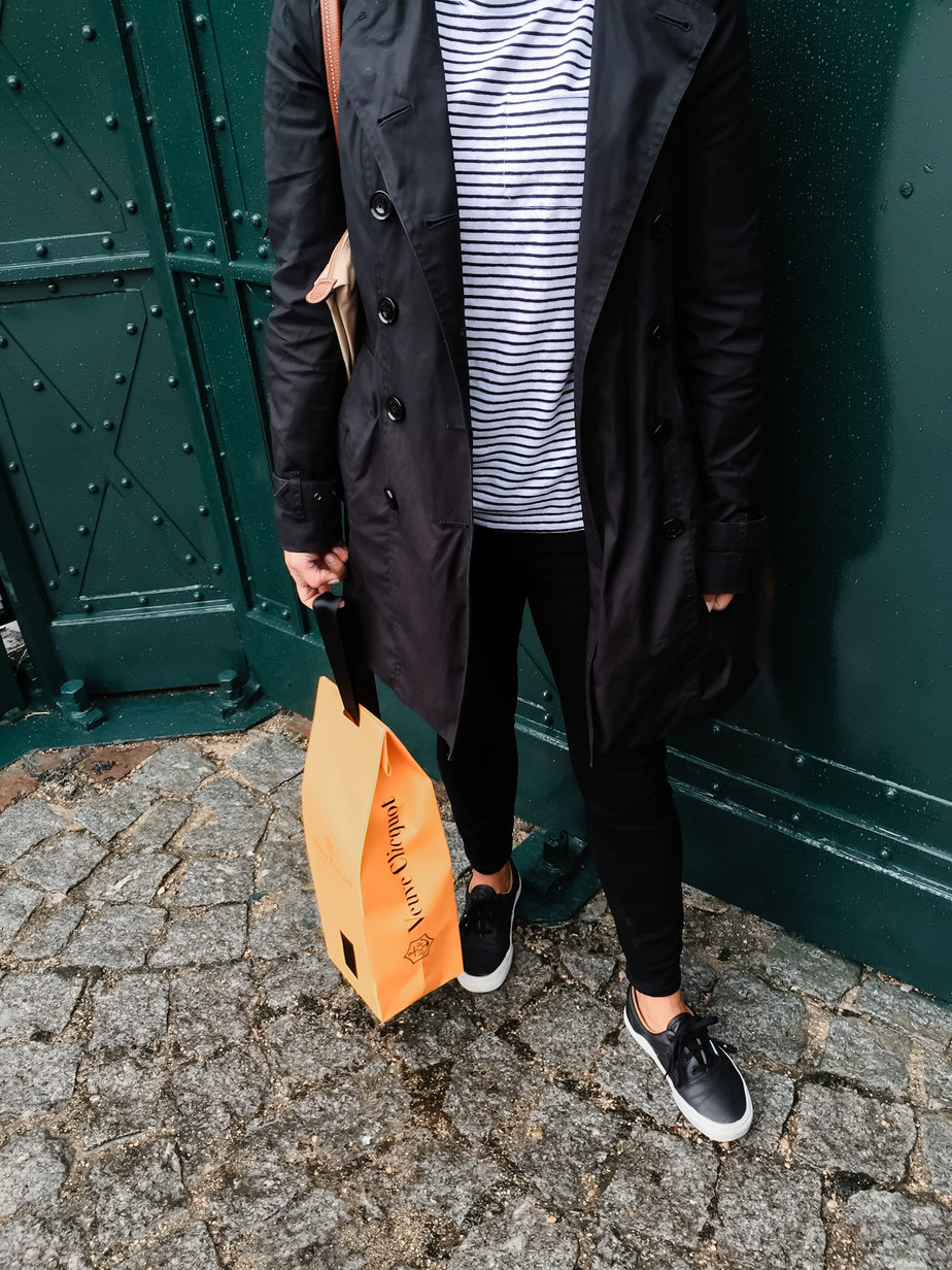 Vevue Cliquot bag Wearing black pants, black jacket and holding Vevue Cliquot bag