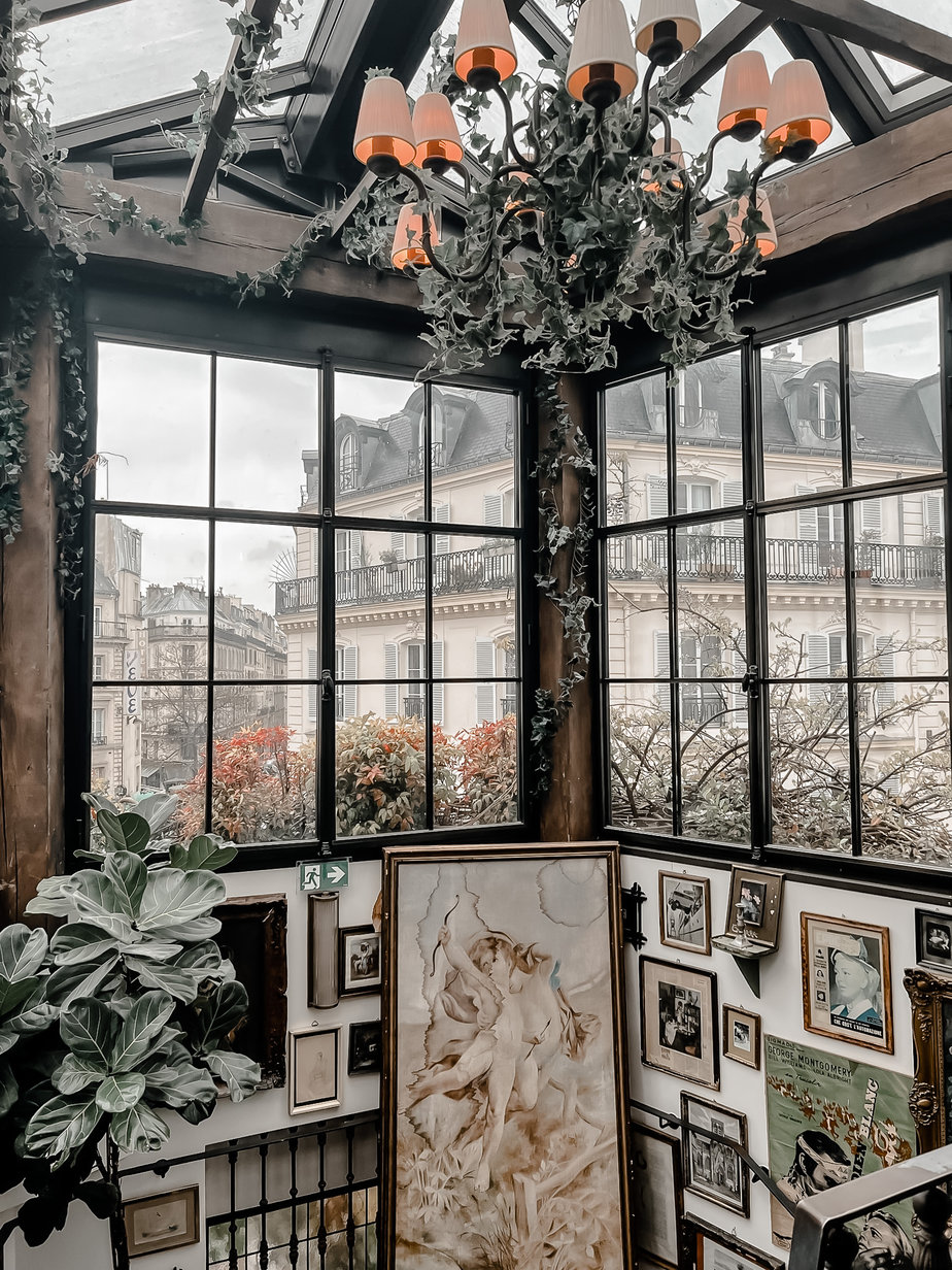 Pictures hanging on a gallery wall with paris in the background