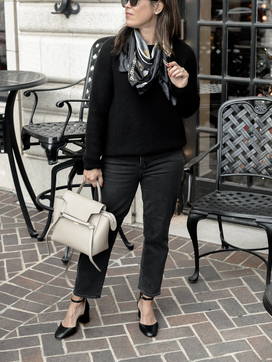 celine micro belt bag for fall with black jeans, black sweater, grey scarf, and black pumps