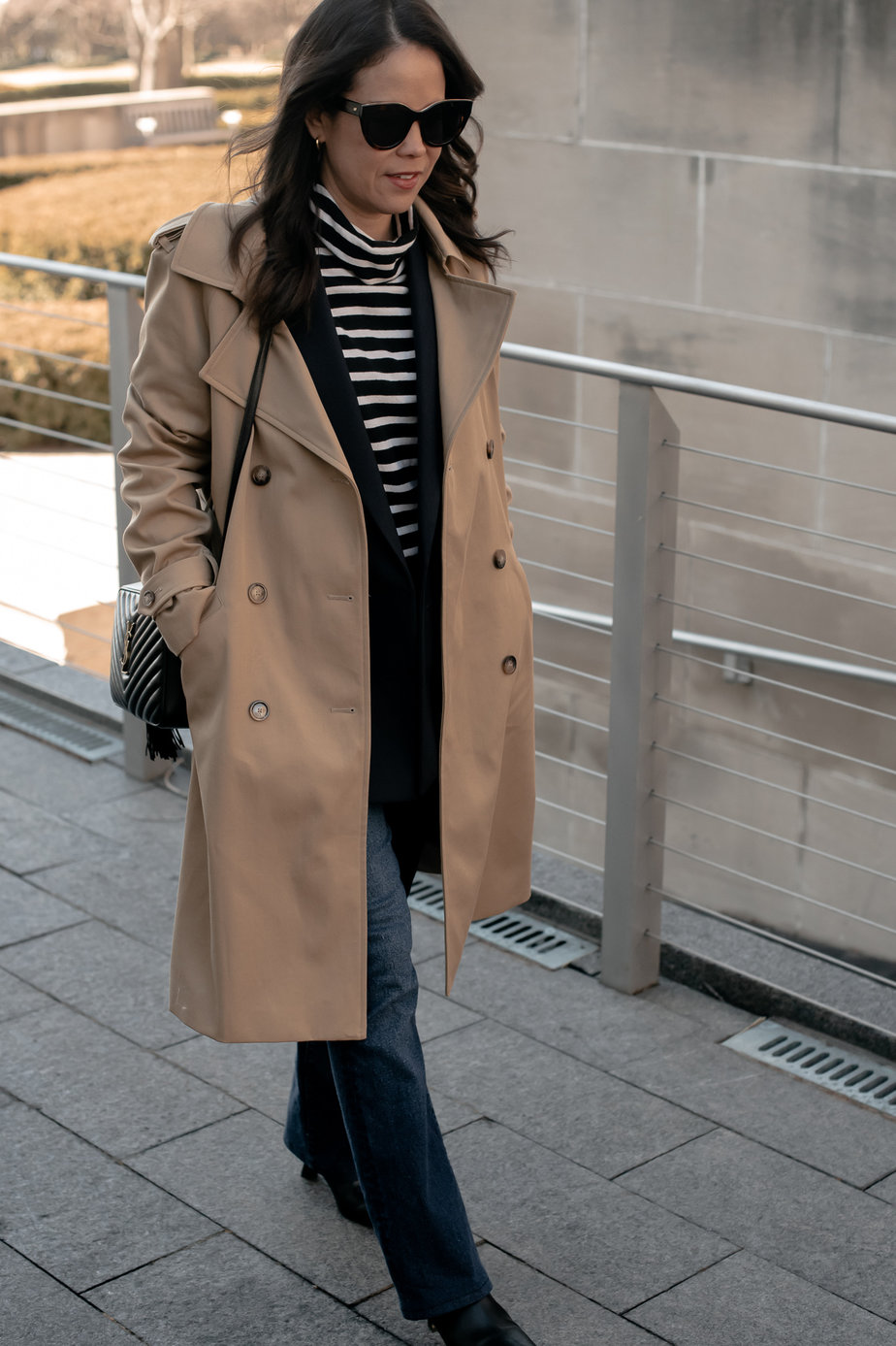Wearing a trench coat with striped turtleneck, trench coat, dark denim, and boots.