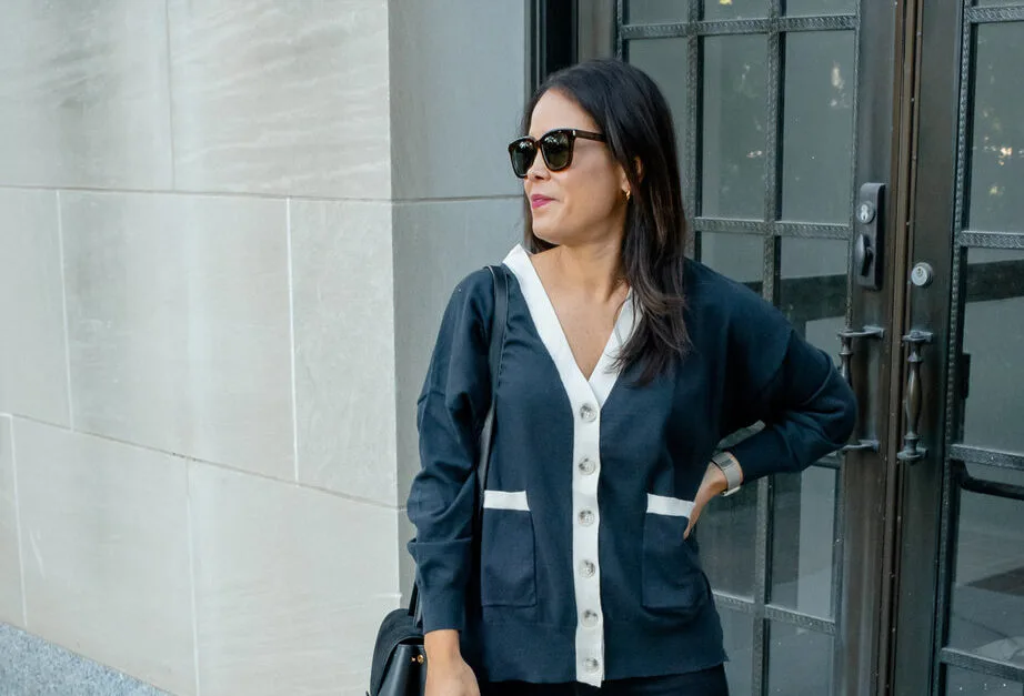 Girl wearing mer sea navy cardigan with black jeans, boots, and black handbag