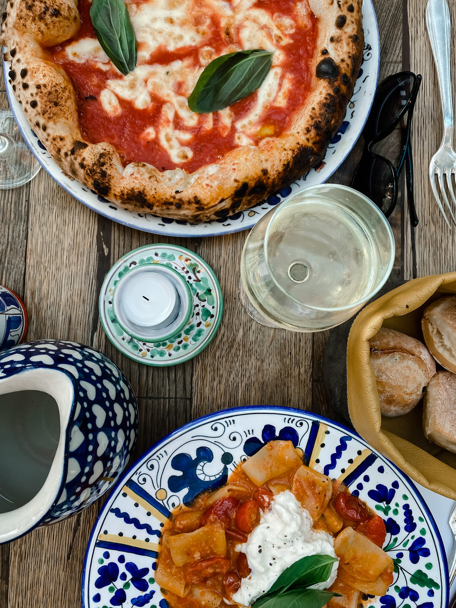 Italian food sitting on two colored plates on a table