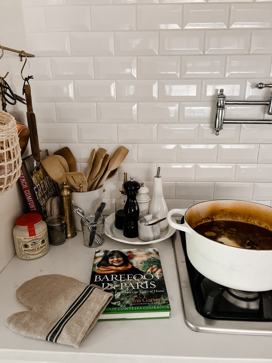Pot of Ina Garten Beef Stew sitting atop a stove with the lecruset lid off the top