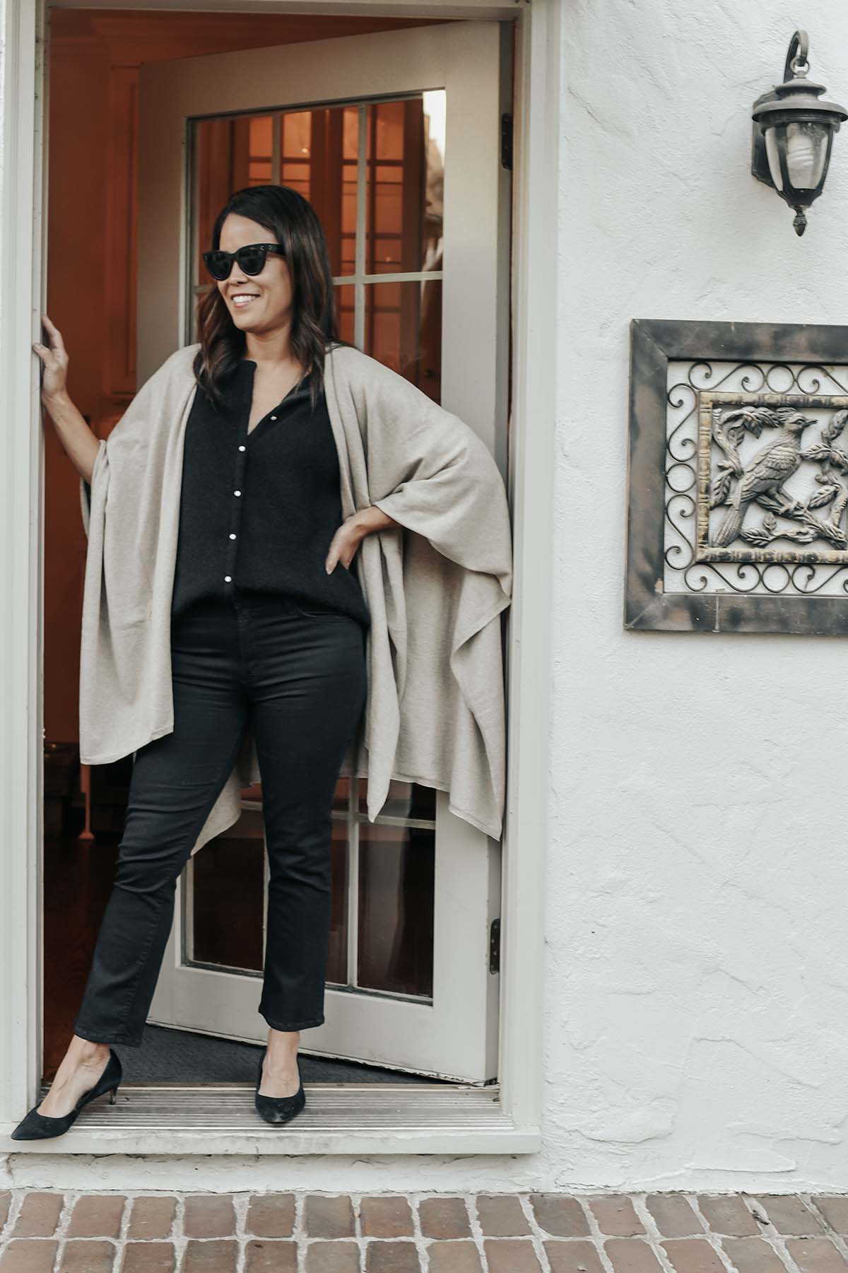 standing in a doorway with brown wrap and all black outfit