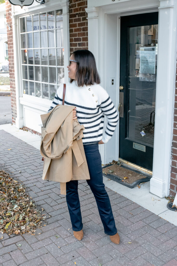 Lady wearing striped sweater with dark denim, brown boots, and striped sweater