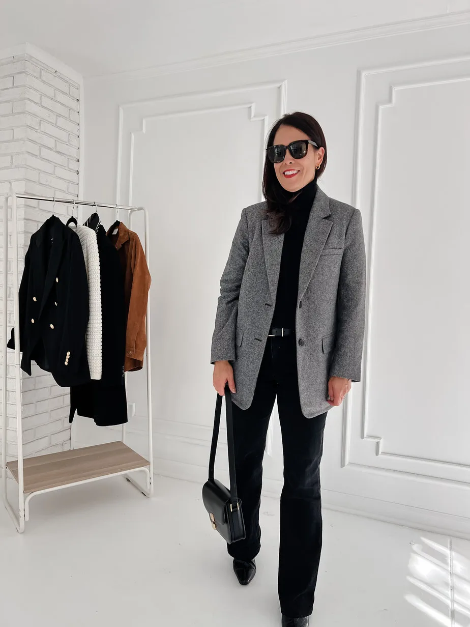 Wearing grey black with black denim, black turtleneck, black boots, and black handbag
