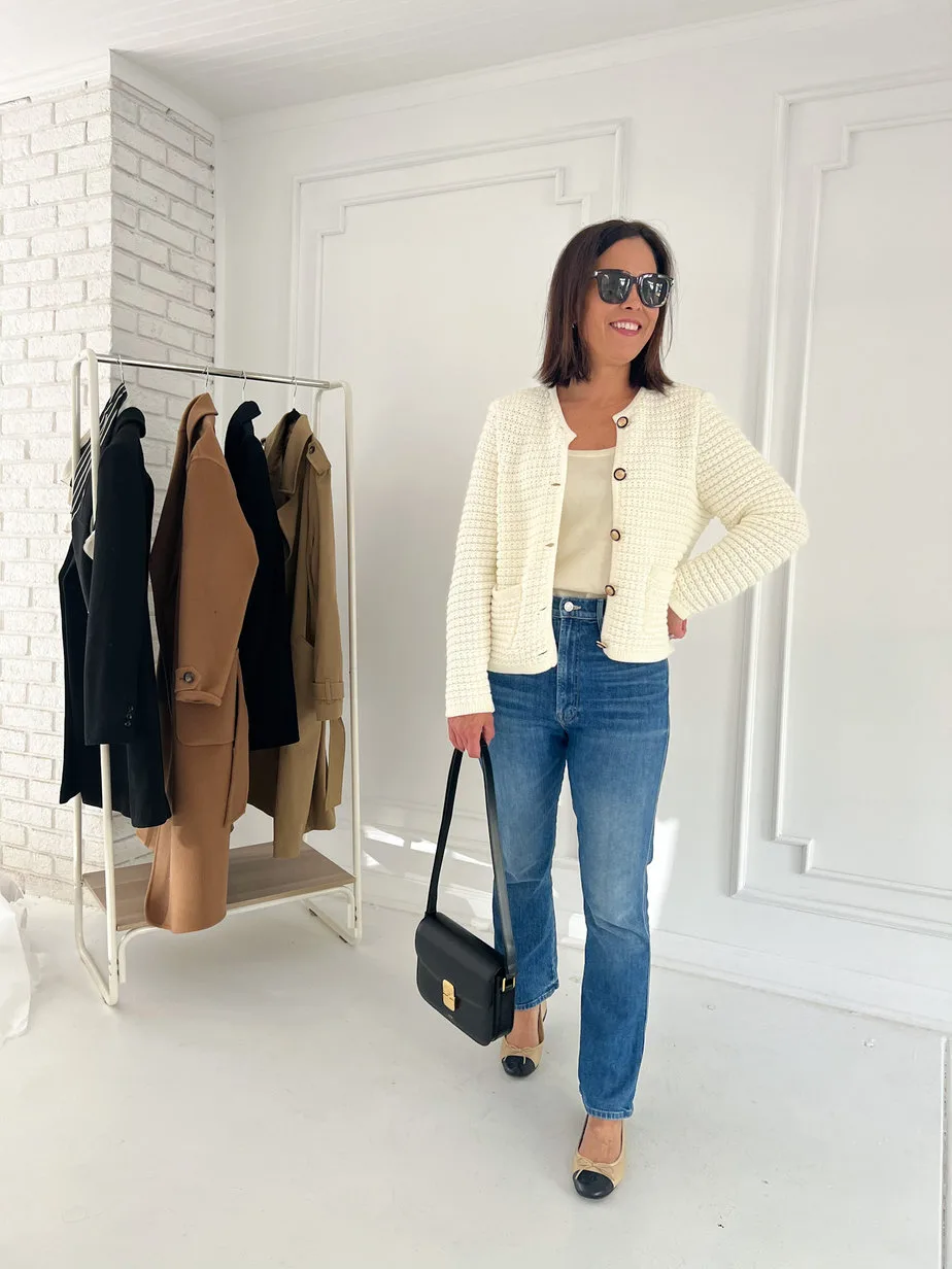 wearing white cardigan with denim, ballet flats, and carrying leather bag