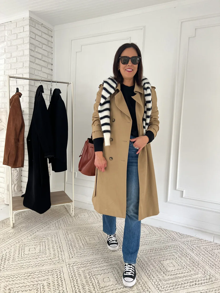 Wearing womens trench coat with striped sweater, black high top converse, and brown leather bag.