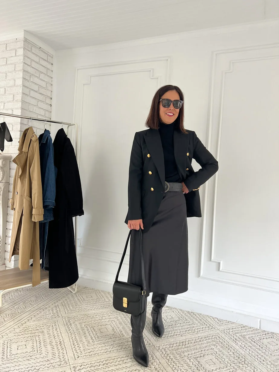Lady wearing black slip skirt with black blazer and tall black boots