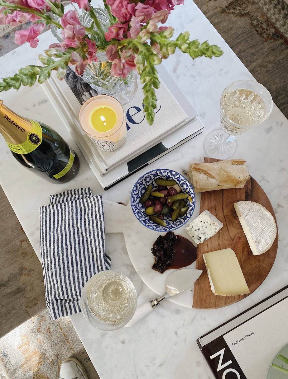 cheese platter on a table with wine bottle