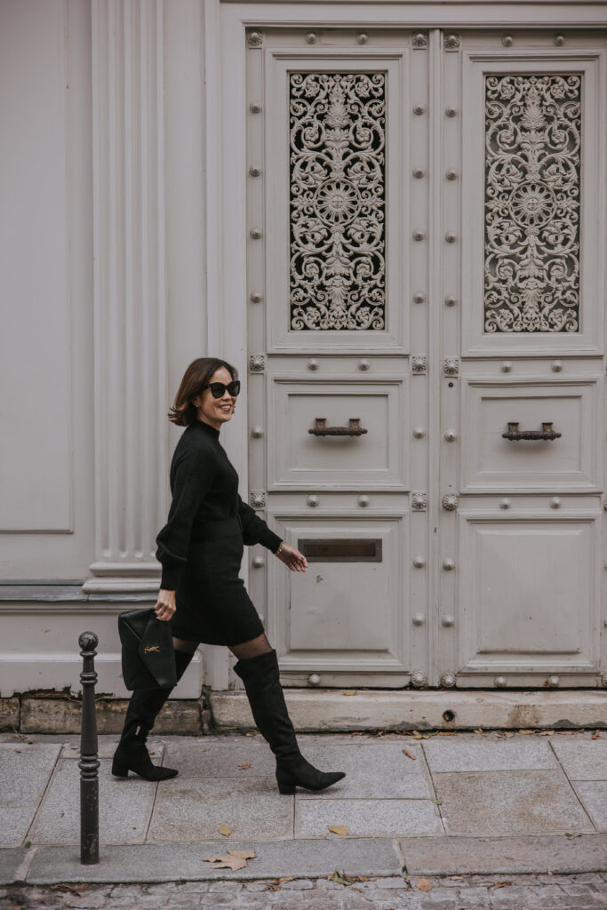 Woman walking with sweater dress and knee high boots in Paris.