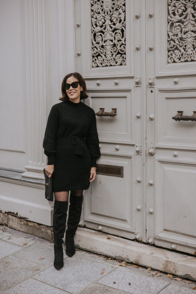 Woman standing against door in Paris.