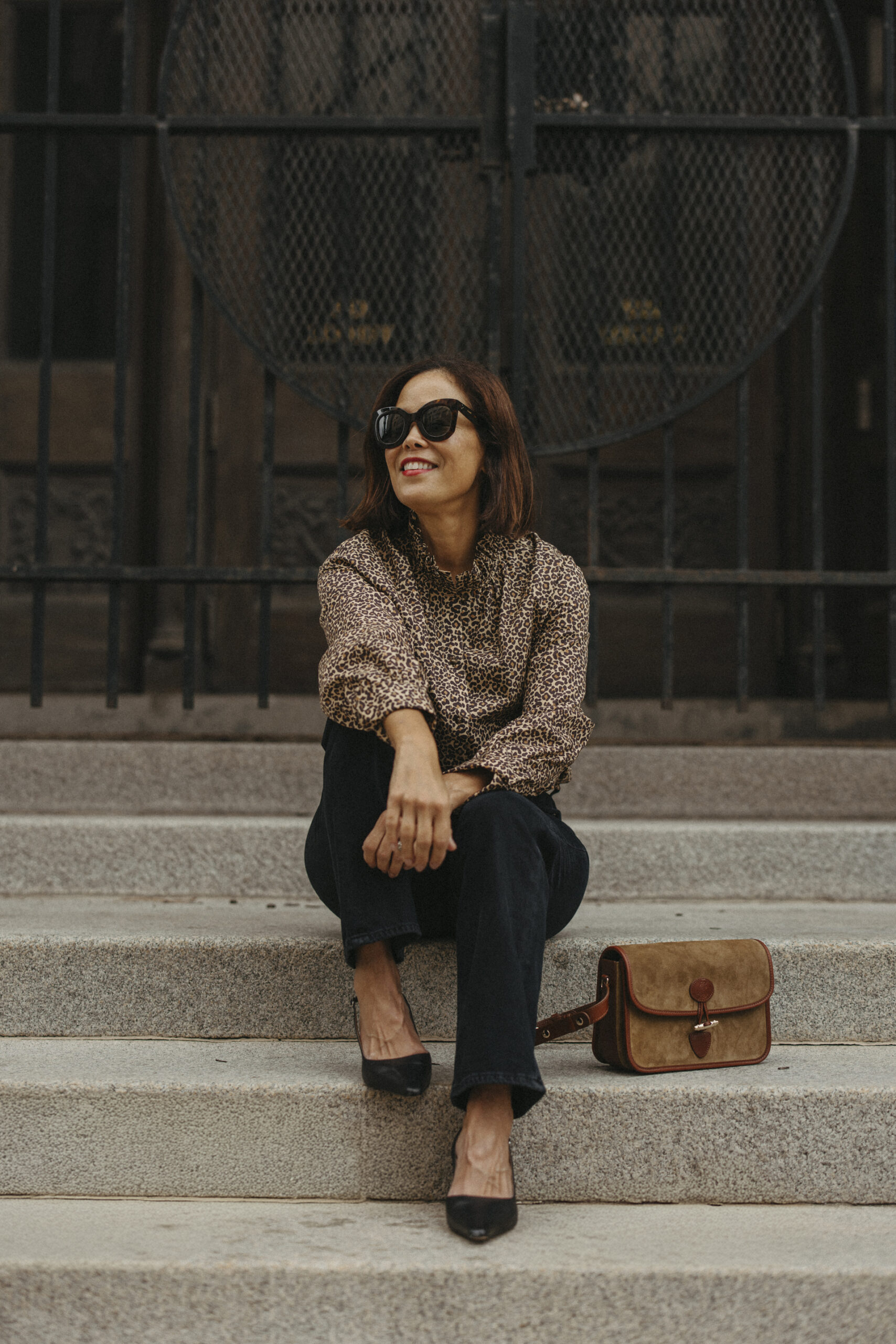 Woman sitting on step with sezane milo handbag.