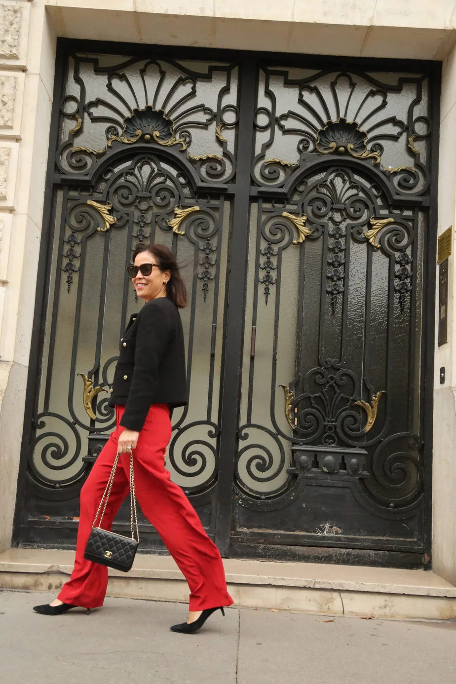 woman with red pants, and black tweed jacket in paris.