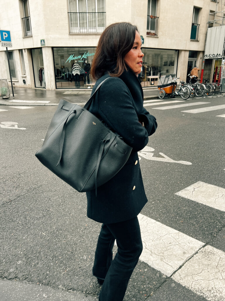 Wearing black coat with jeans, black bag, and navy coat in Paris for street style.