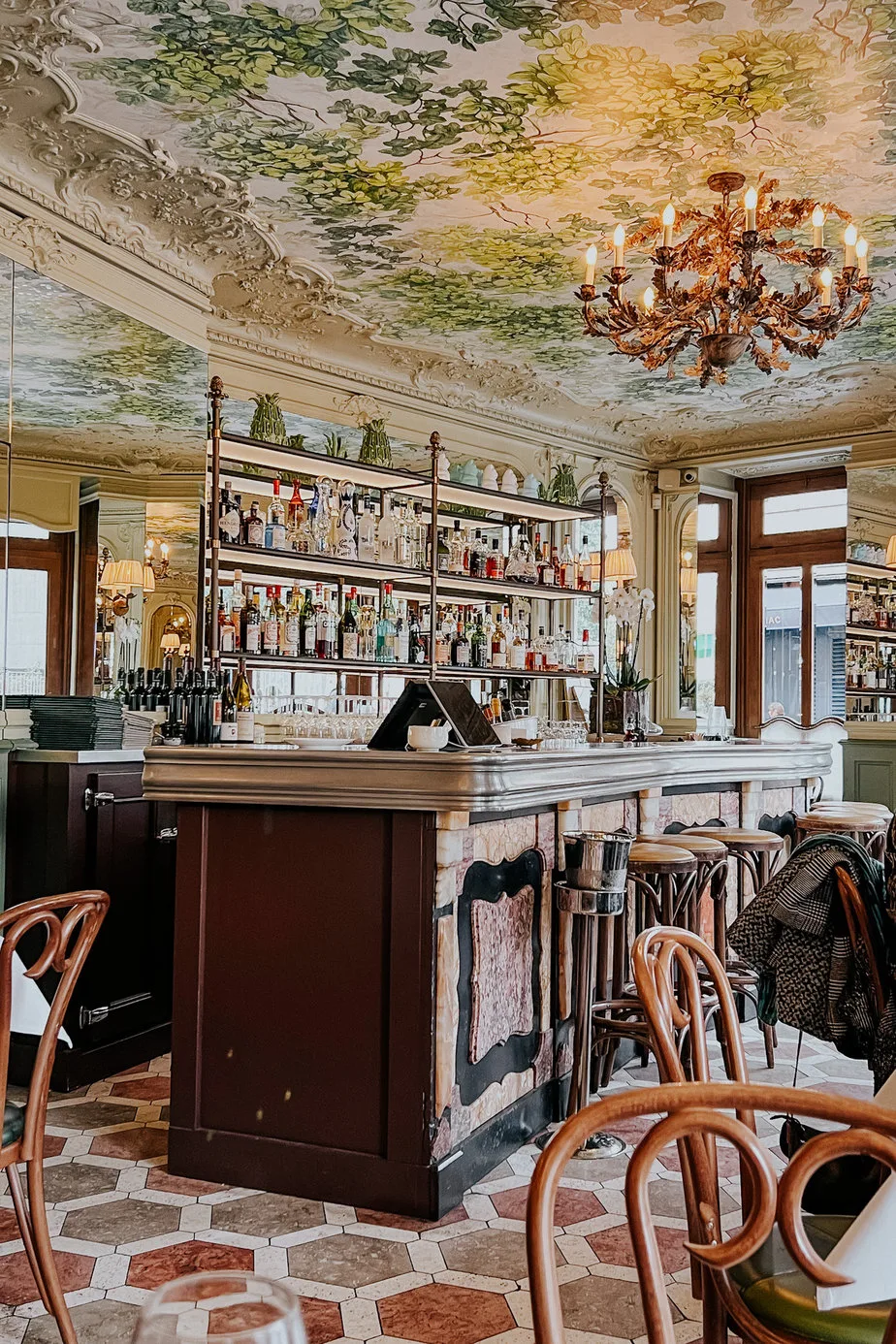 Inside bar with green moulding on ceiling and wood marble on the bartop at where to eat in Paris.