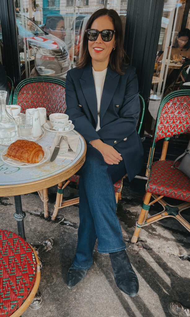 Wearing navy blazer with cream sweater and jeans in Paris.