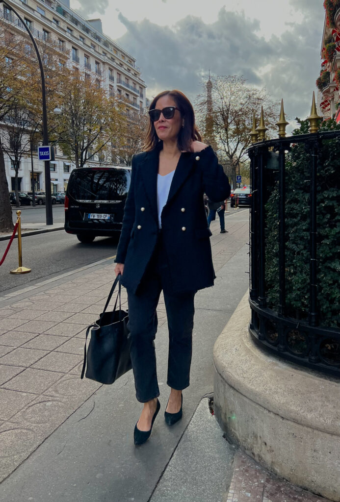 Black tweed blazer and jeans walking down street in Paris.