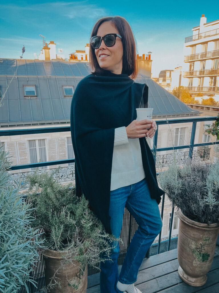 My Parisian style in a black wrap and sweater standing on a terrace in Paris