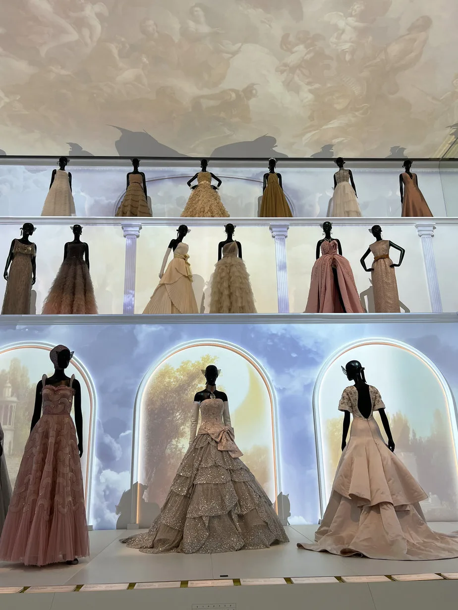 16 gorgeous dresses of pink, white, on display in a room at the la galerie dior in paris.