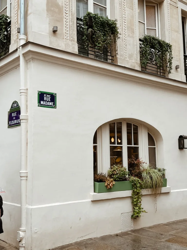 Exterior of Hotel Bonsoir Madame in Paris with window boxes of flowers.