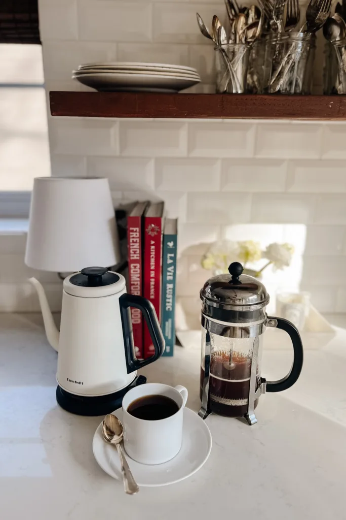 French press and kettle sitting on a counter.