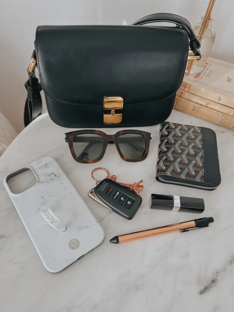 A.P.C. Grace bag sitting on table with wallet, sunglasses, keys, lipstick, pen, and phoen cover.