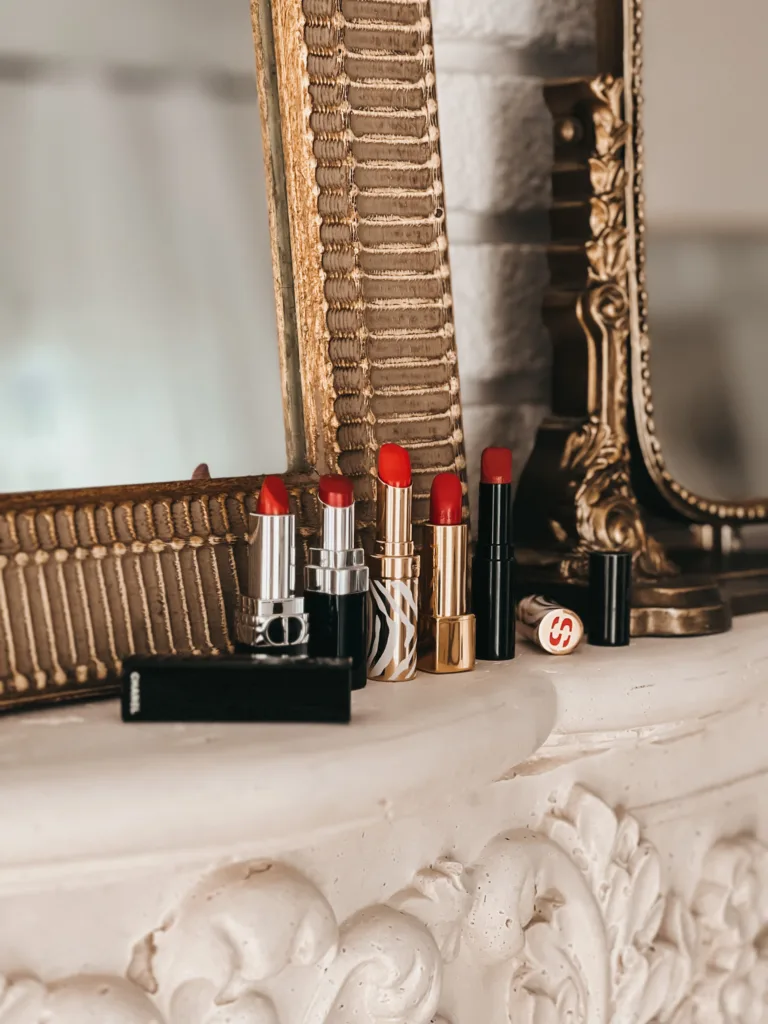 5 RED LIPSTICKS ON A MANTLE.