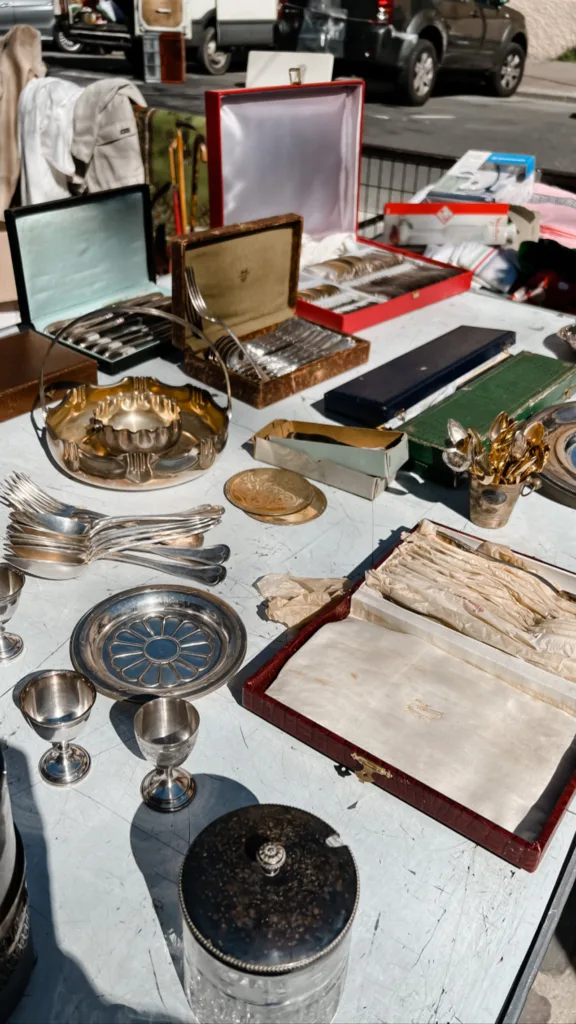 ash tray, book, sitting on a table of other collectibles | Best Flea Market In Paris