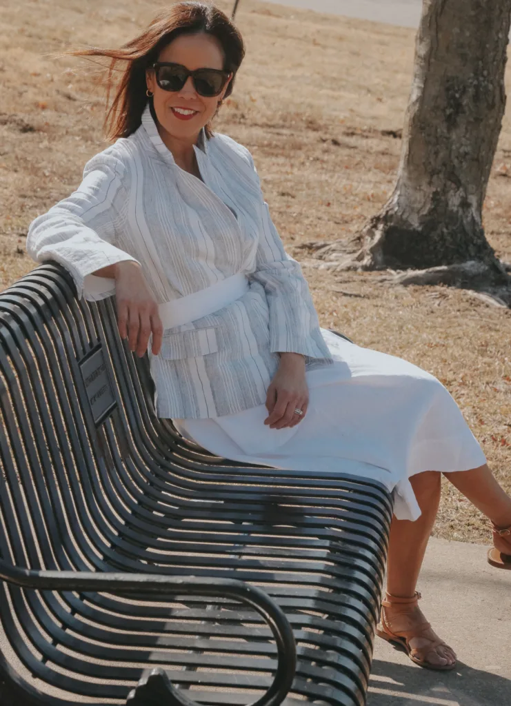 Lady in a striped blazer and white dress.