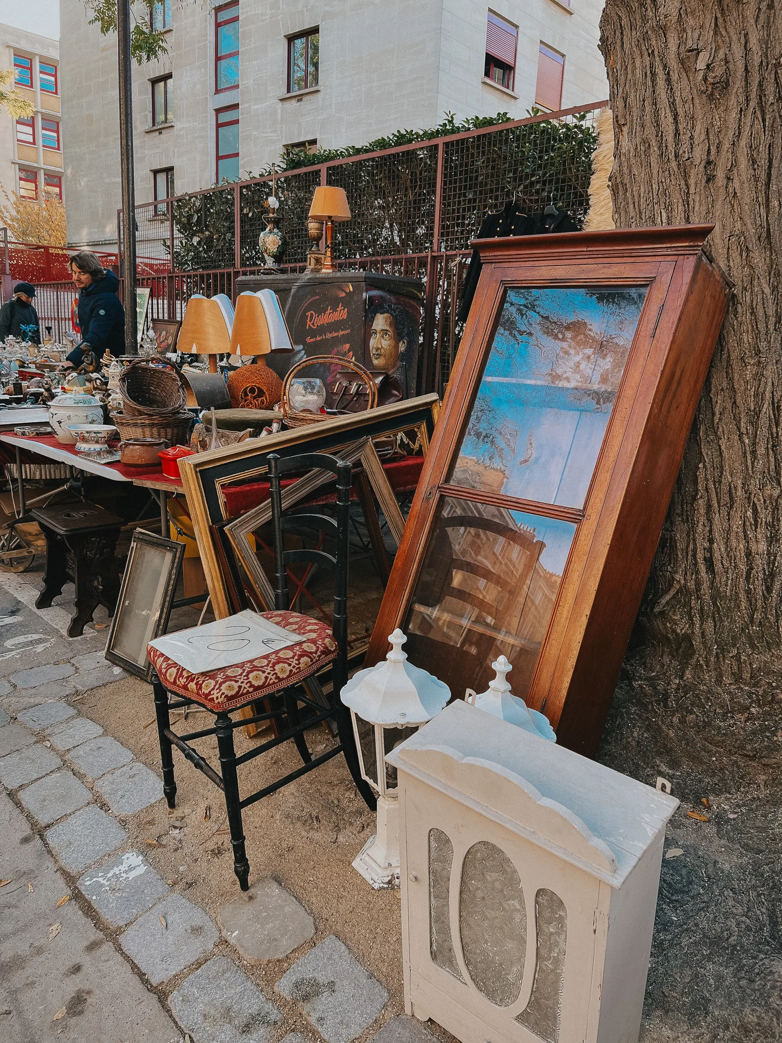 flea market finds, mirror against a tree, stool on the street.
