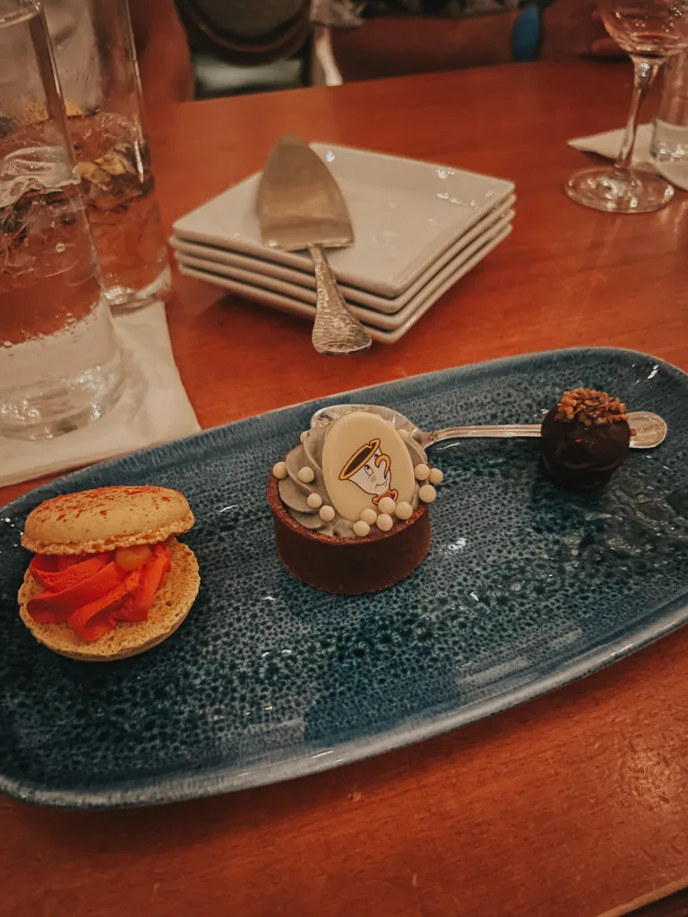 French desserts of a macarron, truffle, and tart sitting on a plate | French inspired things at Disneyworld