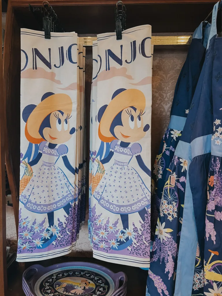 Minnie Mouse towels that say Bonjour hanging from a rack.
