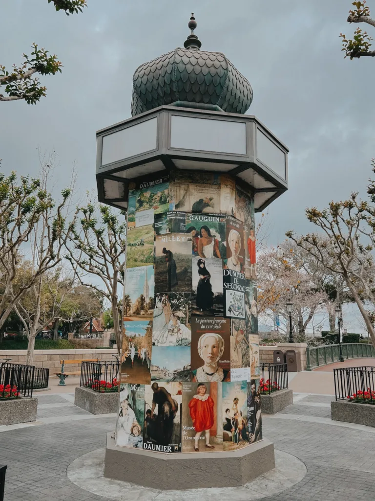 Posters and pictures on a rolling billboard that look Parisian.