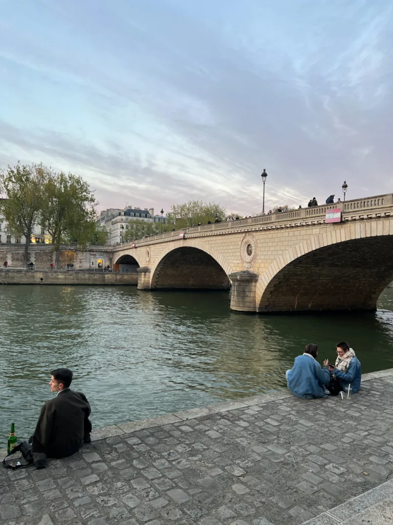 People sitting along the seine.
