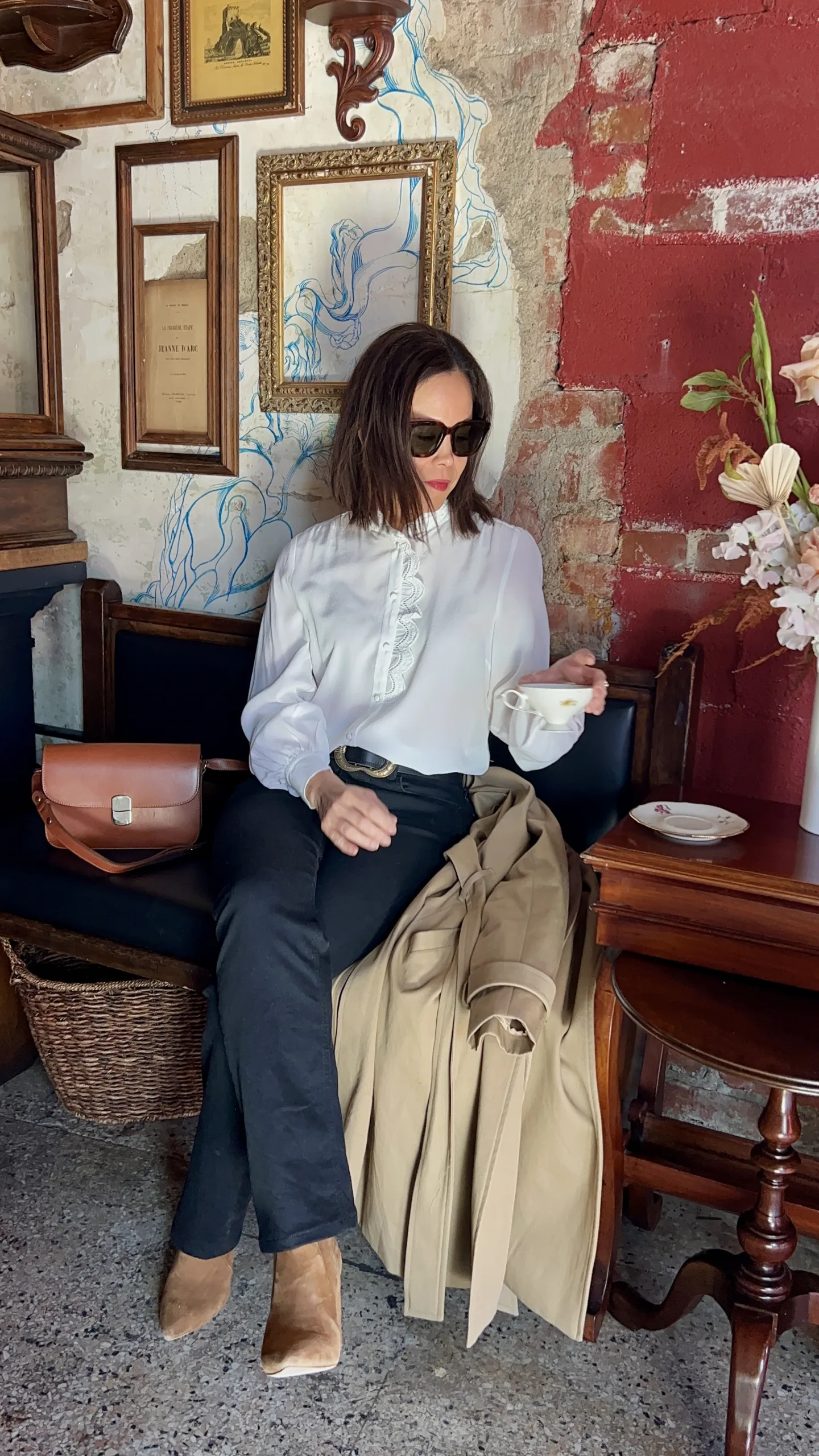Women wearing white silk top with jeans and boots.