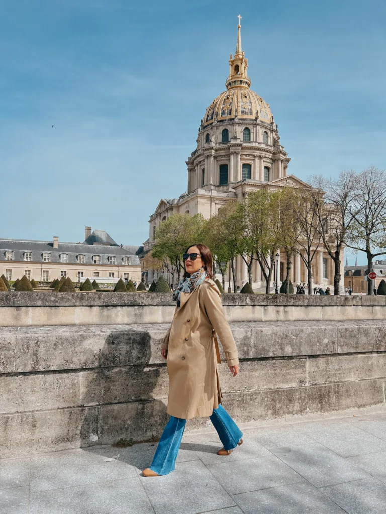 Lady wearing trench coat, flare jeans, boots in Paris.