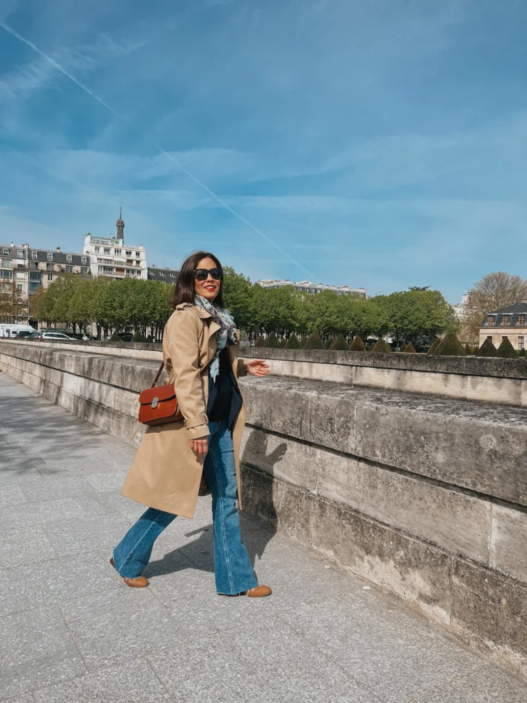 Lady wearing jeans with trench coat, brown purse, in Paris.