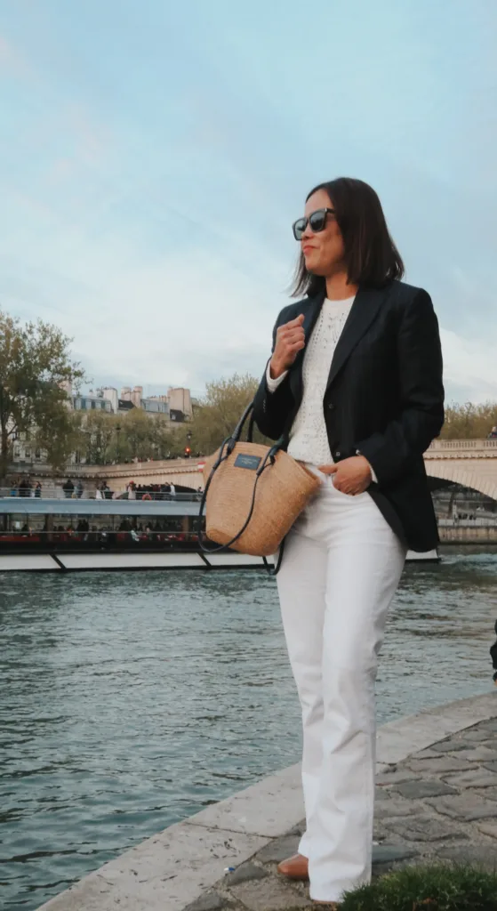 Lady wearing navy blazer with white denim, market tote.