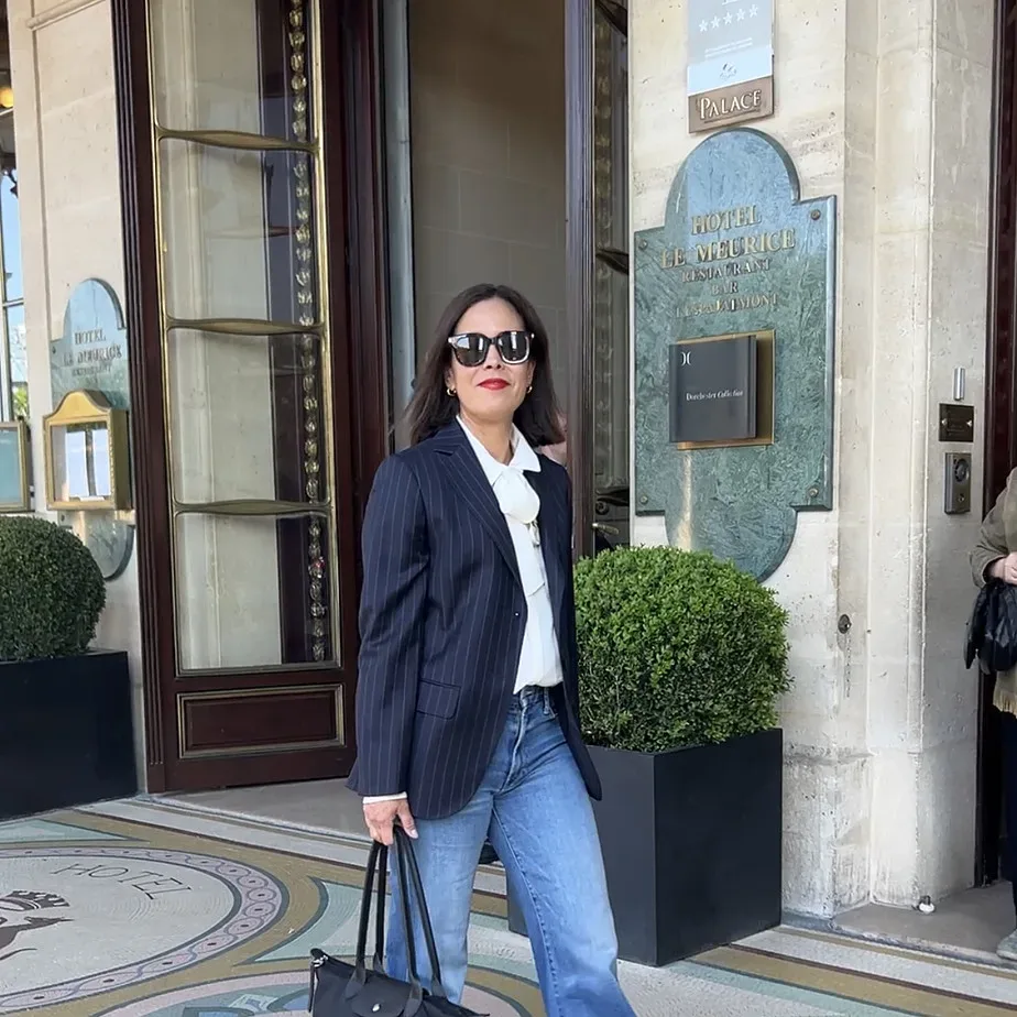 Woman wearing navy blazer with white tee and jeans.