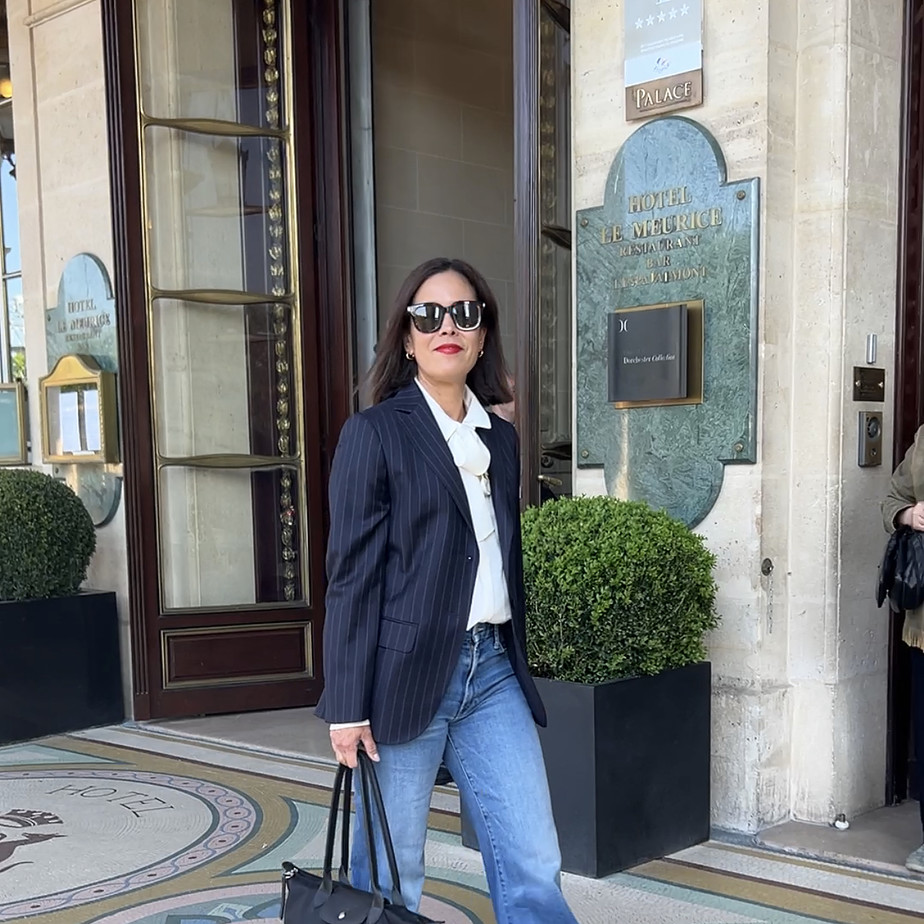 Woman wearing navy blazer with jeans and Longchamp tote in Paris.