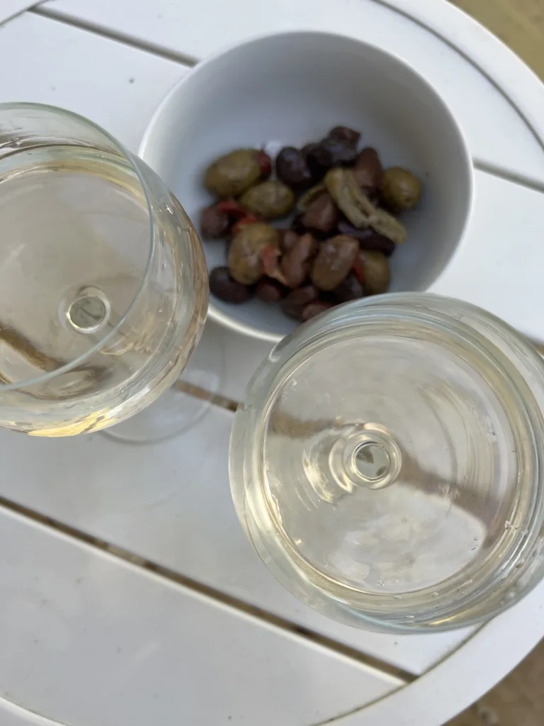 Two glasses of wine with bowl of Olives for a French apero.