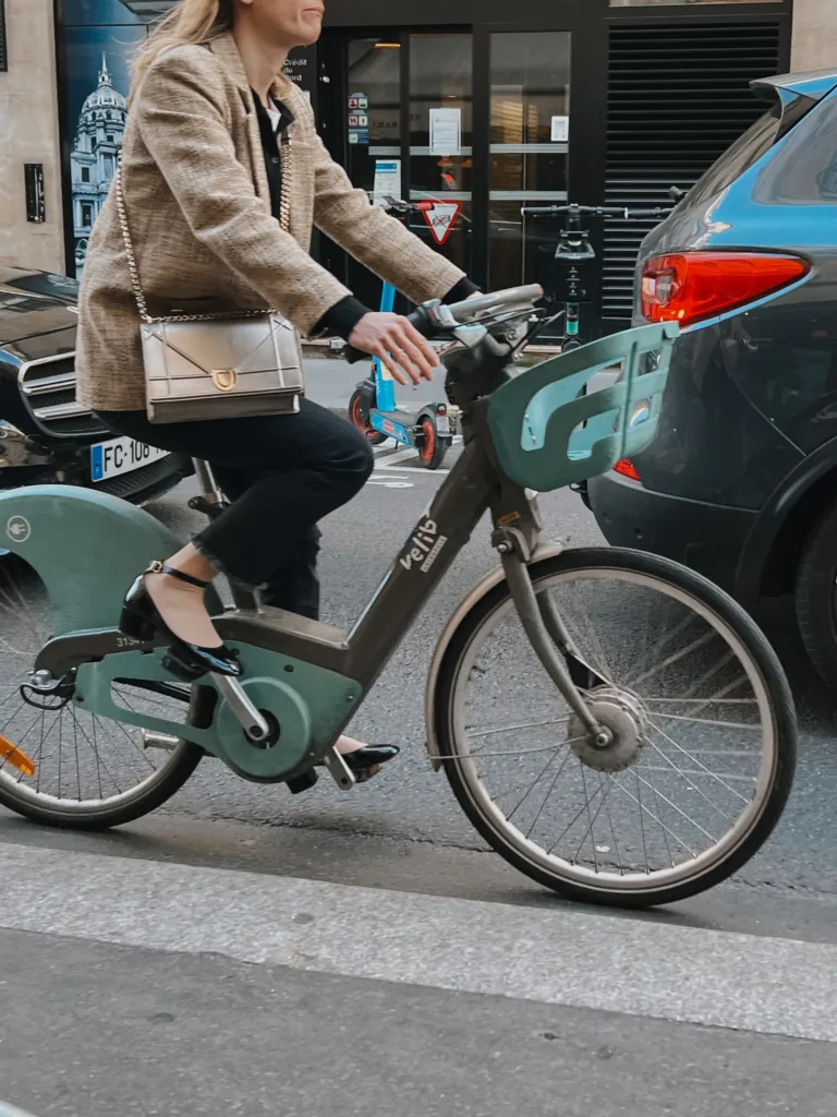 Lady on a bike in Paris wearing mary janes and blazer.