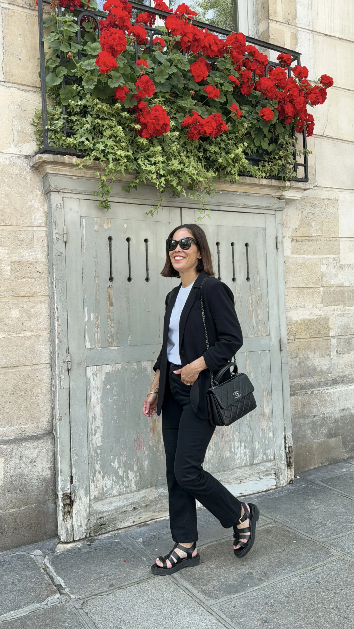 woman wearing black blazer with black jeans and sandals. 