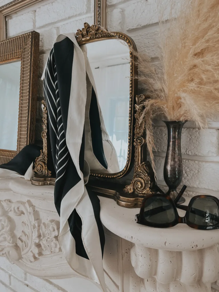 Gold mirror sitting on mantle.