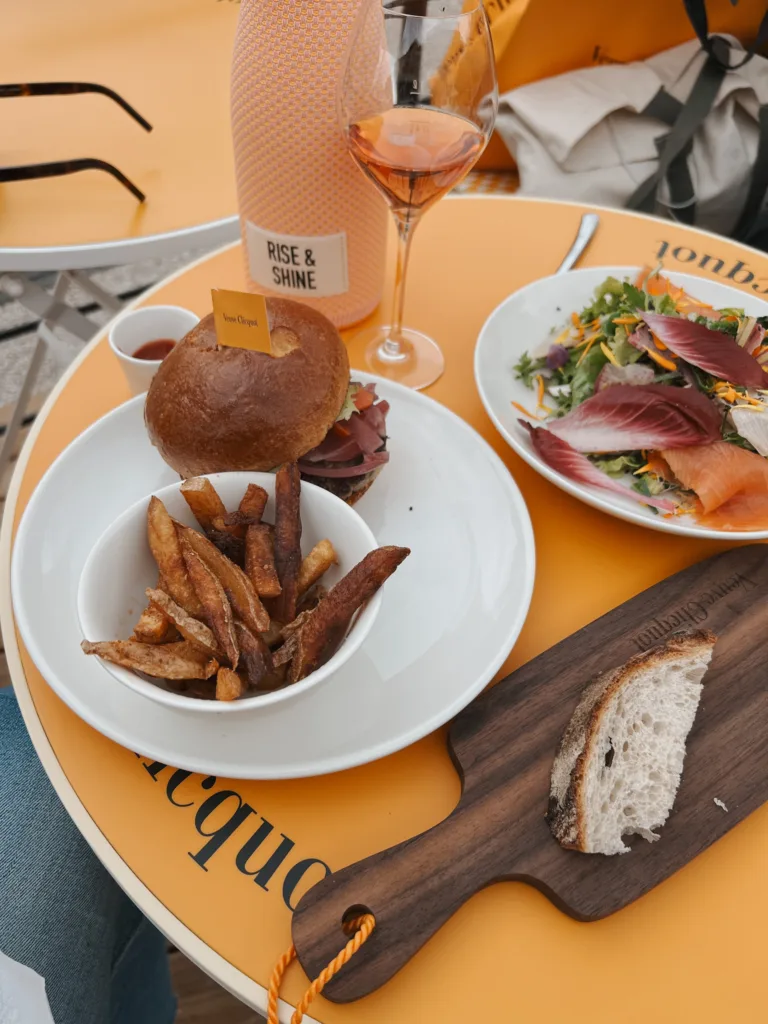 Hamburger and salad sitting on a table at Veuve Clicquot in Paris.