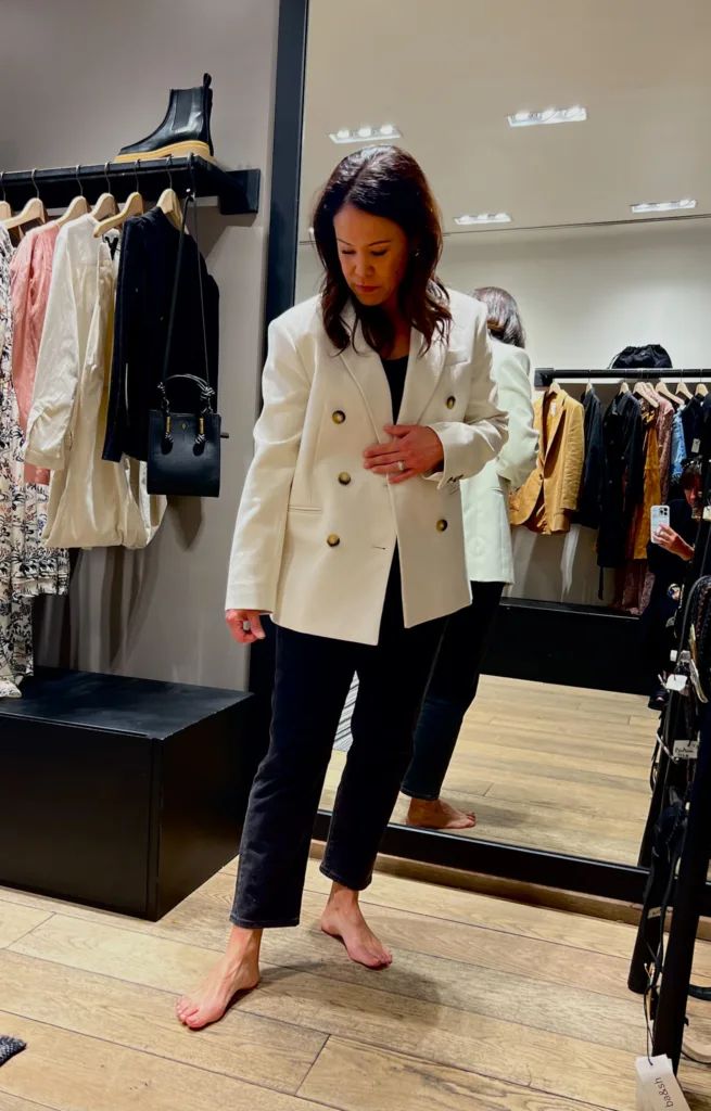 woman wearing white blazer and black jeans.