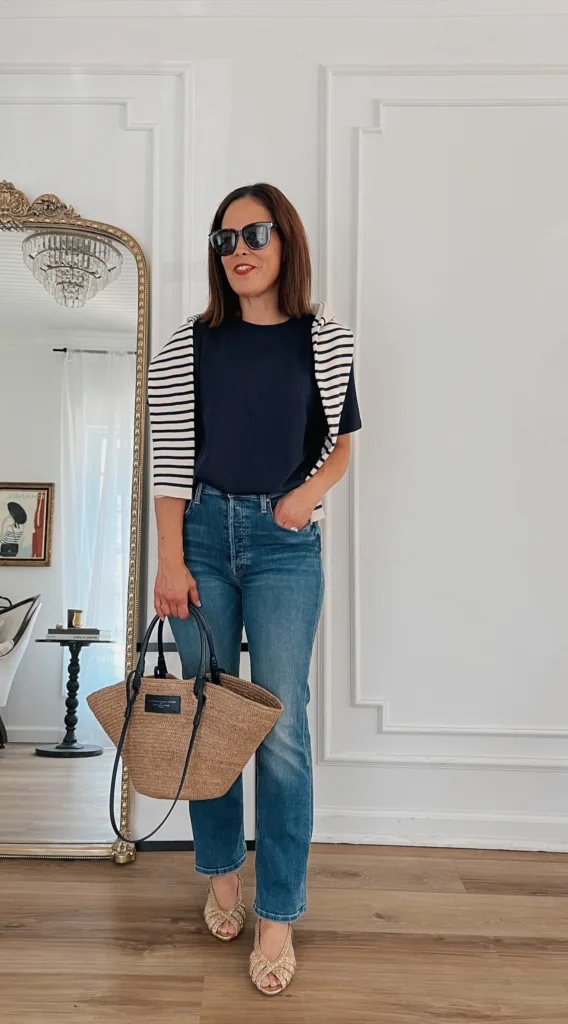 Woman with striped sweater, navy t-shirt and jeans.