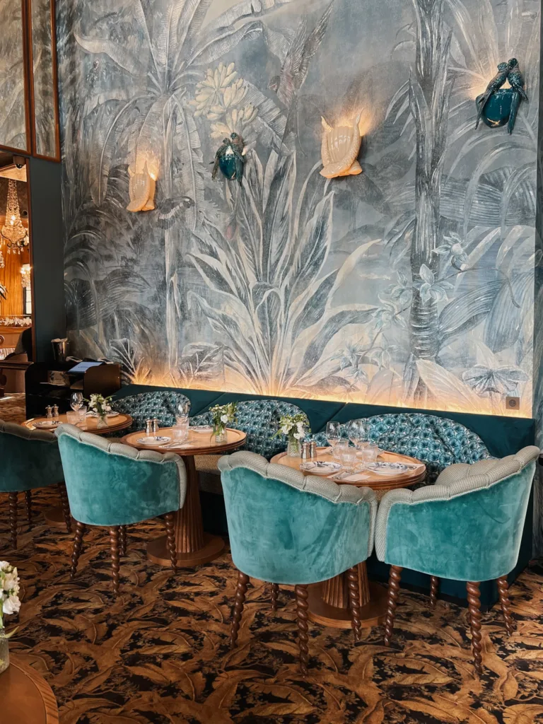 Interior of a cafe with blue suede chairs and wallpaper.