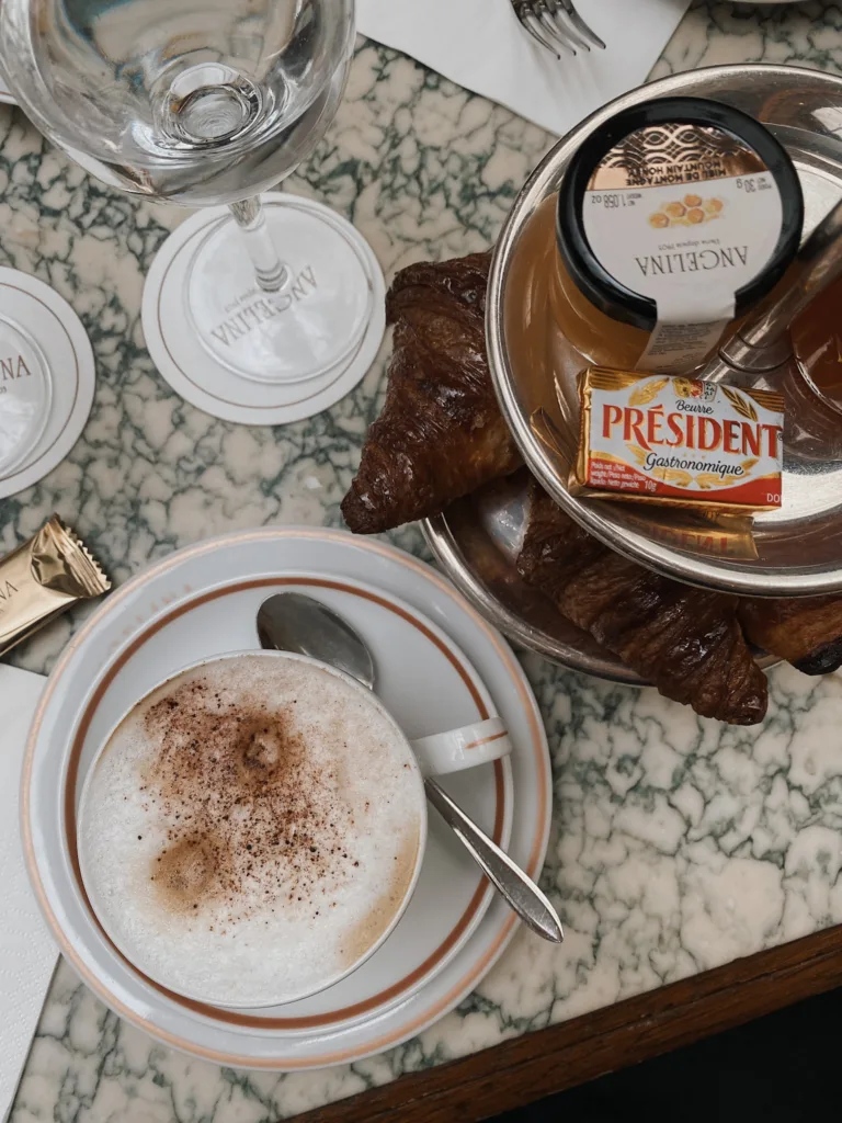 Inside of Angelina's restaurant in Paris with butter, latte sitting on the table.